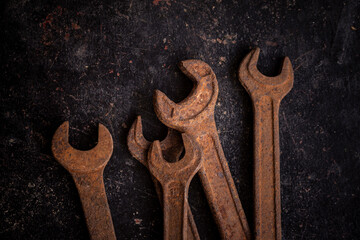 Old rusty wrenches on a dark background