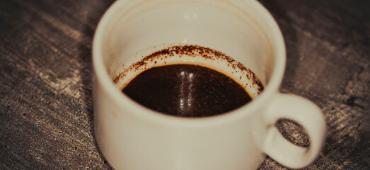 A dirty white coffee cup on the wooden table