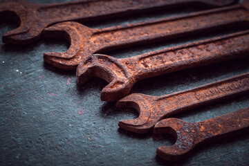 Vintage wrenches covered with rust on a dark background