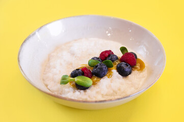 Vegan rice porridge with berries in a white plate