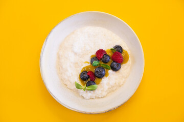 Vegan rice porridge with berries in a white plate