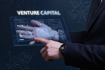Business, Technology, Internet and network concept. Financial Graph. Stock Market chart. Young businessman working on a virtual screen of the future and sees the inscription: Venture capital