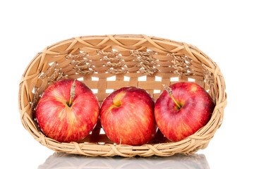 Three juicy red apples with a basket, close-up isolated on white.