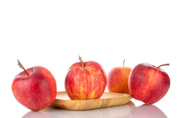 Several juicy red apples on a wooden tray, close-up isolated on white.
