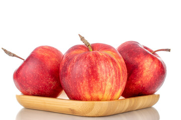 Three juicy red apples on a wooden tray, close-up isolated on white.