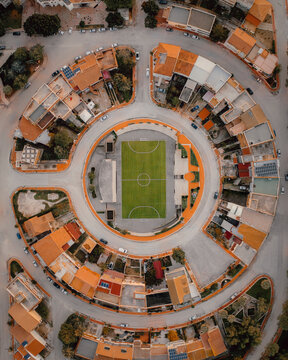 Aerial view of a football pitch surrounded by houses in a circle, Poggioreale, Sicily.