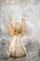 Christmas decorative nacreous toy angel with a book in his hands and a white beautiful background with bokeh. 