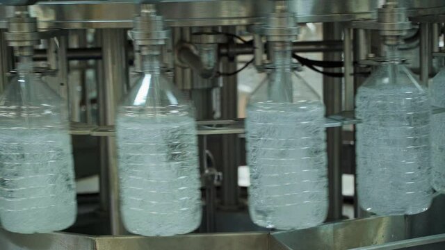 Plastic large bottles getting filled in factory