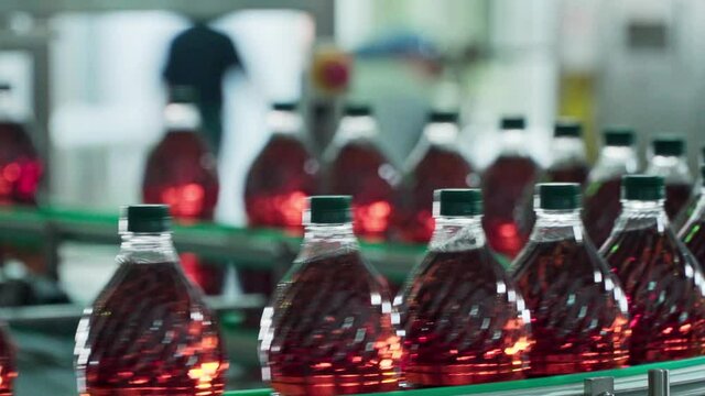 Bottles filled with red liquid on a conveyor belt