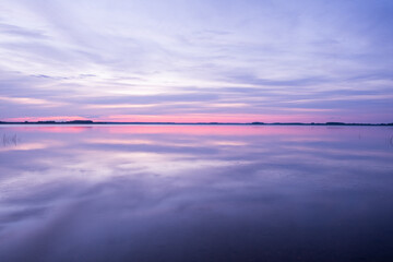 Nice sunset over lake, the sky is reflected in the water, Kostroma, Russia