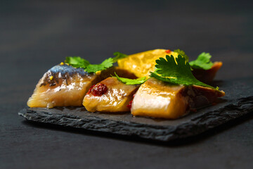 Pieces of herring fillet are covered with oil, spices and herbs.