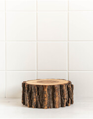 Round natural wooden podium mockup for eco, food or beauty product on white tile background.