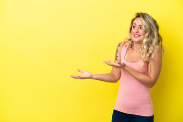Young Brazilian woman isolated on yellow background with surprise expression while looking side