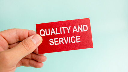 message on the card with text quality and service, in hand of businessman.