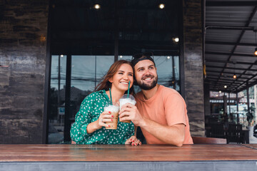 Fototapeta na wymiar Beauty couple drinking smoothie on cafe hipster style, beard man, woman in the dress, happy face, love romantic,Couple having coffee at a coffee shop. Man and woman meeting at cafe,Attractive smiling