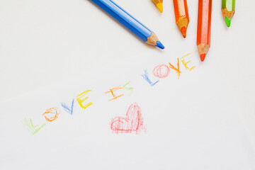 Handmade color drawing on a white sheet with the text love is love and a red heart, representing the LGBTQ + community, close-up view