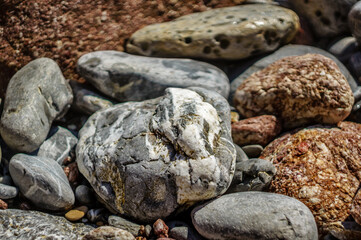 Fototapeta na wymiar Big stones, sea view and sea scooter. Rock full of curves and smooth cuts resulting from the erosive effect of sea.Stones texture and background. Rock texture.Stone