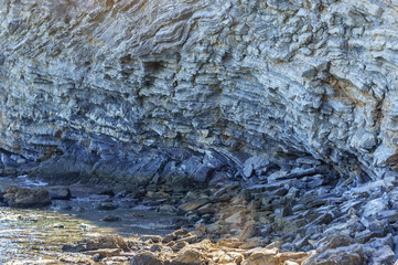 Detail of a rock with variants of blue. Rock full of curves and smooth cuts resulting from the erosive effect of sea.Stones texture and background. Rock texture.Stone