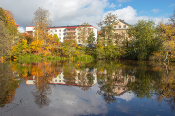Obraz premium Mirror images on water riverbank trees reflected on calm and still water in Autumn