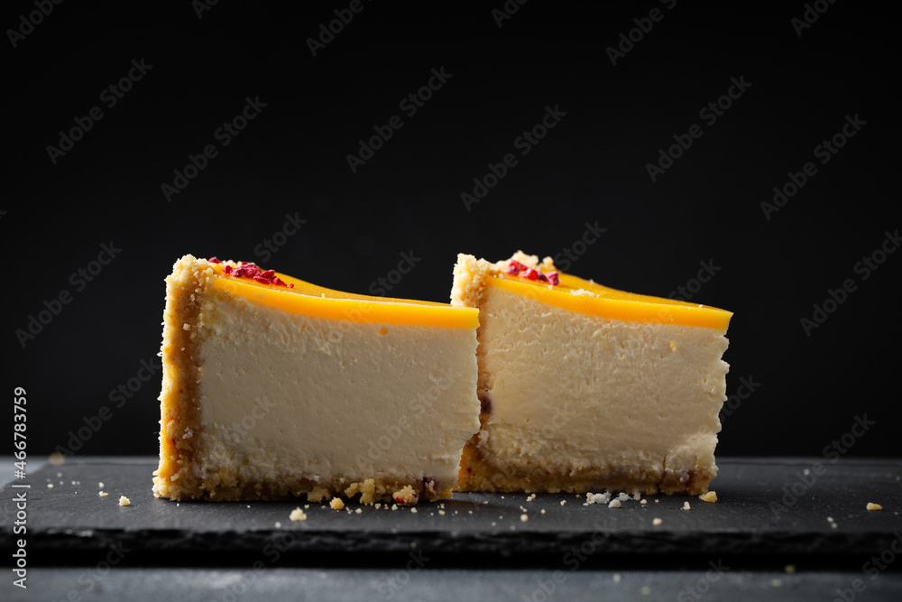 Wall mural cheesecake with yellow mango flavoured layer decorated with red crumbs of freeze-dried raspberries. 