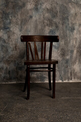 brown, wooden chair on black wall background
