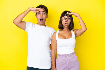 Young mixed race couple isolated on yellow background has just realized something and has intending the solution