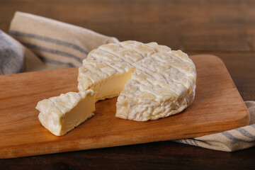 French Saint-Félicien cheese on wooden cutting board