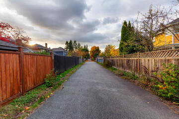 Alley in a residential neighborhood in the city suburbs. Surrey, Greater Vancouver, British Columbia, Canada. Fall Sunset.