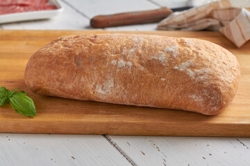 ciabatta is an Italian white bread made from wheat flour water salt yeast olive oil on white wooden background
