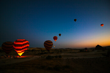 Hot air balloon's preparation for taking off at sunrise in Cappadocia