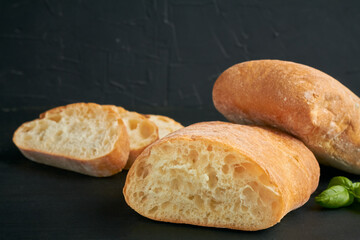 ciabatta is an Italian white bread made from wheat flour water salt yeast olive oil on black background