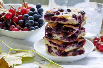 Traditional Italian yeast dough pie with grapes Schiacciata and bunches of grapes on a light background. - 466787516