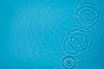 Transparent blue colored clear water surface texture with ripples, splashes and bubbles. Abstract nature background Water waves in sunlight with copy space Cosmetic moisturizer micellar toner emulsion