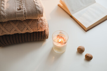 cozy home atmosphere and still life with coffee, candle and sweaters