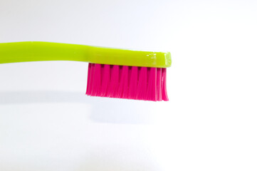 Colored toothbrush with white background.