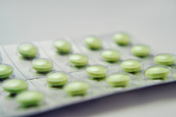Green pills. Blister with pills on white background.