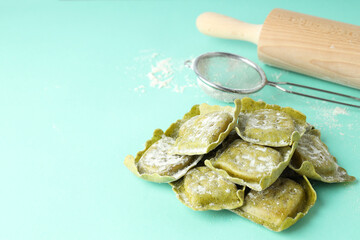 Concept of cooking ravioli on mint background