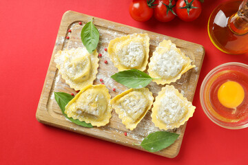 Concept of cooking ravioli on red background