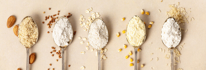 Metal spoons of various gluten free flour almond flour, oatmeal flour, buckwheat flour, rice flour, corn flour , flat lay, top view - obrazy, fototapety, plakaty