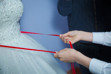 Wedding . Bridesmaids lace bride . Close the ribbon on the belly the bride . Close the ribbon on the belly of the bride . Lose the ribbon on the belly of the bride .