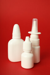 Blank bottles of nasal spray on red background