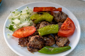 Izgara kofte, traditional Turkish meatball dish, grilled with vegetables on plate. Turkish cuisine photo