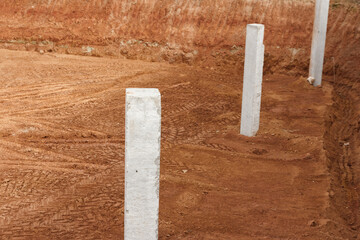 Fototapeta premium Preparation of the pile foundation for the construction of the building. Driven concrete piles. Concrete base. New building construction
