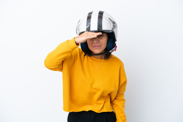 Woman with a motorcycle helmet looking far away with hand to look something