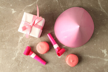 Birthday accessories on gray textured background, top view