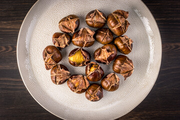 Roasted chestnuts on a plate, top view