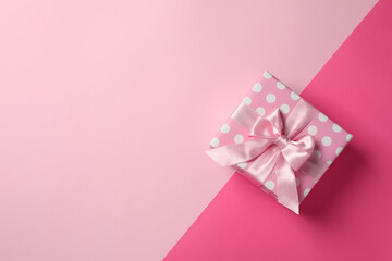 Pink gift box on two tone background