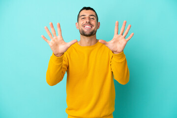 Young handsome caucasian man isolated on blue background counting ten with fingers