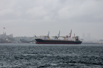 cargo ship in the Bosporus strait with Istanbul city view on background