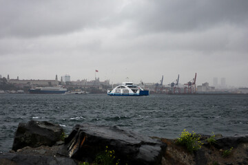 Fototapeta premium passenger ferry crosses the Bosporus strait in Istanbul, Turkey in stormy and rainy day